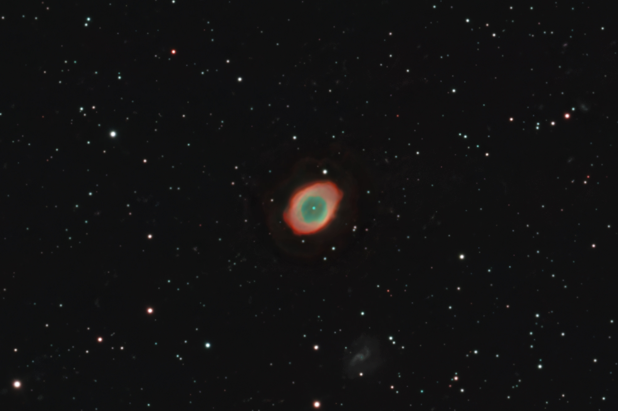 The Ring Nebula Messier 57 is a planetary nebula in the constellation Lyra.  The barred galaxy IC 1296 can be seen slightly below it.